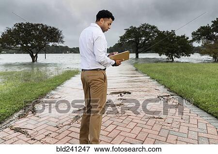Black insurance adjuster examining flooding damage View Large Photo Image Stock Photo - Black insurance adjuster examining flooding damage. Fotosearch