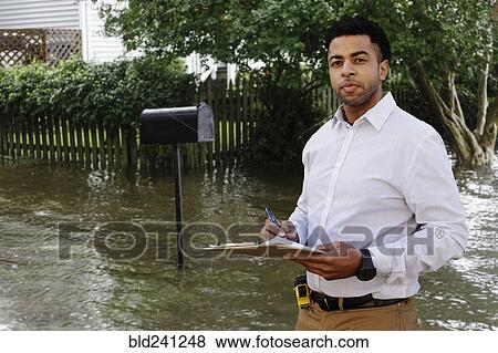 Black insurance adjuster examining flooding damage to house View Large Photo Image Stock Photo - Black insurance adjuster examining flooding damage to house. Fotosearch