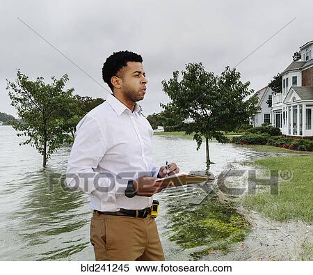 Black insurance adjuster examining flooding damage to house View Large Photo Image Stock Photography - Black insurance adjuster examining flooding damage to house. Fotosearch
