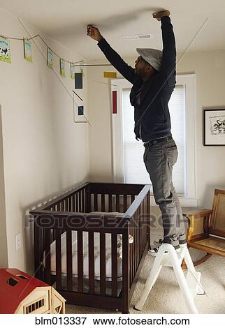 Black man decorating bedroom View Large Photo Image Stock Photo - Black man decorating bedroom. Fotosearch