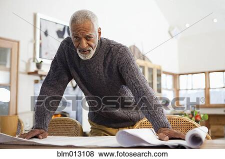 Stock Photo - Black man looking at blueprints. Fotosearch