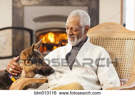 Stock Photograph - Black man petting dog. Fotosearch