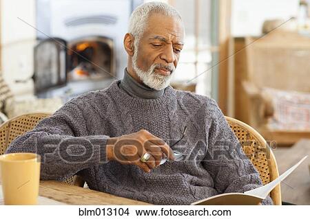 Picture - Black man reading book. Fotosearch