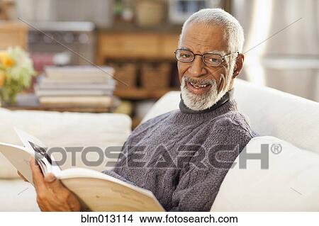 Picture - Black man reading book. Fotosearch