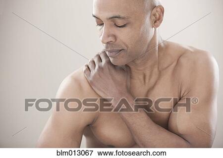 Stock Photo - Black man rubbing his shoulders. Fotosearch