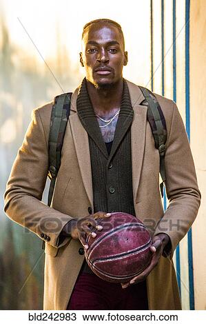 Black man wearing backpack holding basketball View Large Photo Image Stock Image - Black man wearing backpack holding basketball. Fotosearch