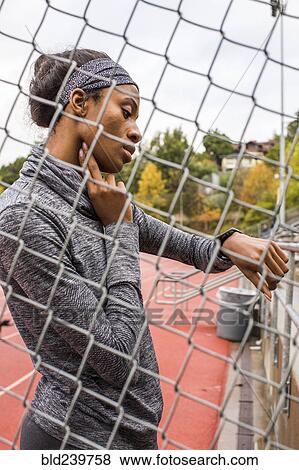 Black woman behind chain-link fence checking pulse View Large Photo Image Stock Photo - Black woman behind chain-link fence checking pulse. Fotosearch