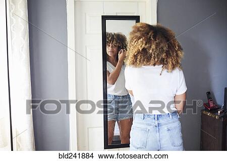 Black woman examining hair in mirror View Large Photo Image Picture - Black woman examining hair in mirror. Fotosearch