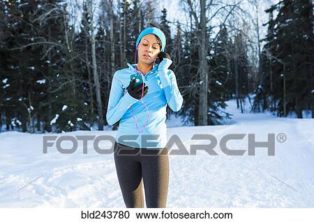 Black woman listening to cell phone with earbuds View Large Photo Image Stock Image - Black woman listening to cell phone with earbuds. Fotosearch