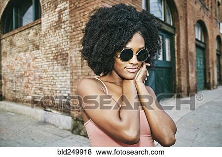 Black woman near corner of brick building View Large Photo Image Stock Photo - Black woman near corner of brick building. Fotosearch