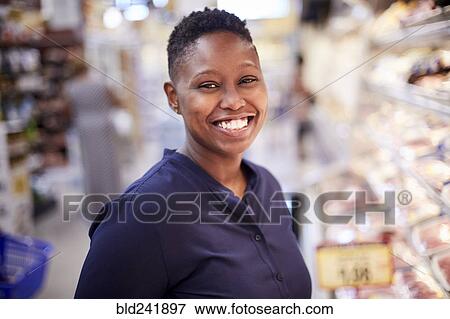 Stock Photo - Black woman smiling in grocery store. Fotosearch