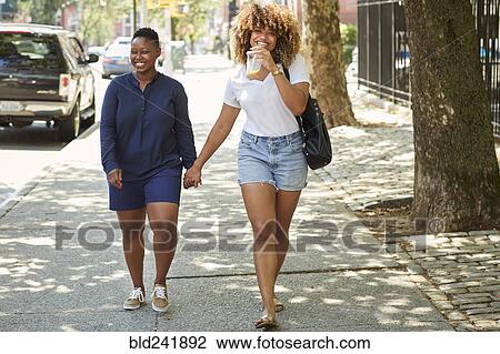 Black women holding hands on city sidewalk View Large Photo Image Stock Image - Black women holding hands on city sidewalk. Fotosearch