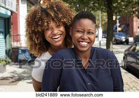 Black women smiling on city sidewalk View Large Photo Image Stock Photo - Black women smiling on city sidewalk. Fotosearch