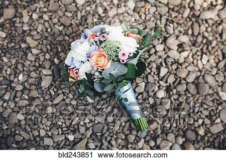 Stock Image - Bouquet of flowers laying on rocks. Fotosearch