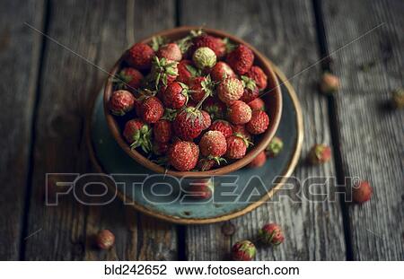 Bowl of red strawberries on wooden table View Large Photo Image Stock Image - Bowl of red strawberries on wooden table. Fotosearch