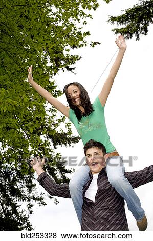 Stock Photo - Boy carrying girl on shoulders. Fotosearch
