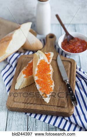 Stock Photo - Bread with caviar on cutting board. Fotosearch