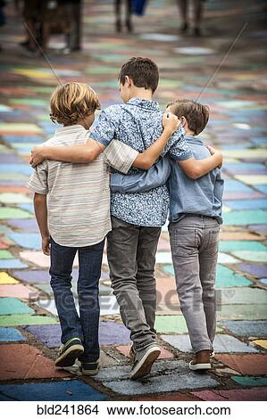 Picture - Brothers hugging and walking. Fotosearch