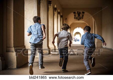 Brothers running near pillars View Large Photo Image Stock Photography - Brothers running near pillars. Fotosearch