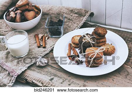Stock Image - Bundles of cookies tied with string on plate near ingredients. Fotosearch
