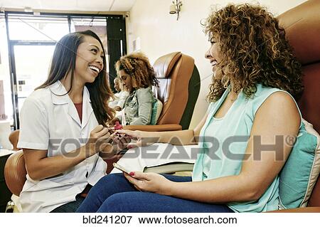 Business owner assisting customer in nail salon View Large Photo Image Stock Photo - Business owner assisting customer in nail salon. Fotosearch