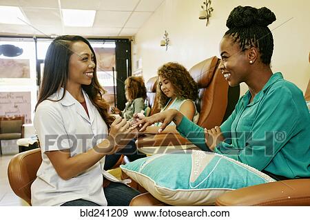 Business owner assisting customer in nail salon View Large Photo Image Stock Photo - Business owner assisting customer in nail salon. Fotosearch