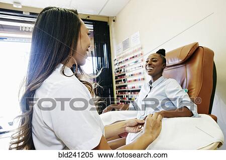 Business owner assisting customer in nail salon View Large Photo Image Stock Photography - Business owner assisting customer in nail salon. Fotosearch