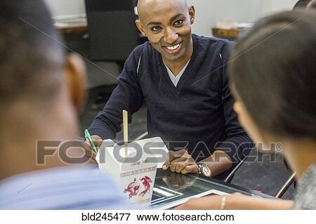 Business people eating food during meeting View Large Photo Image Stock Photo - Business people eating food during meeting. Fotosearch