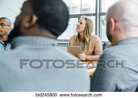 Stock Image - Business people listening in meeting. Fotosearch