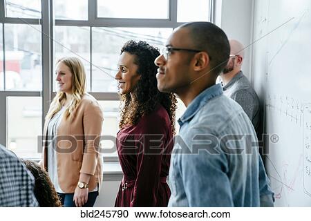 Stock Image - Business people near whiteboard. Fotosearch