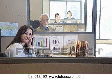Stock Image - Business people sitting in cubicles. Fotosearch