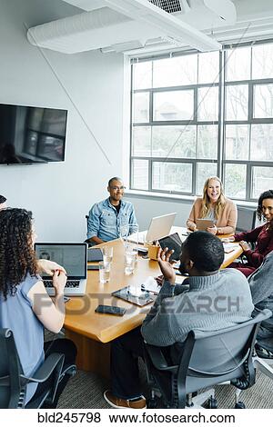 Business people smiling in meeting View Large Photo Image Stock Photo - Business people smiling in meeting. Fotosearch