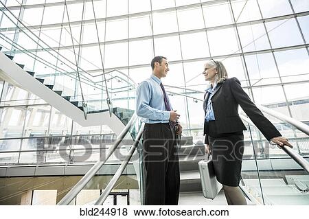 Stock Photo - Business people standing on staircase and talking. Fotosearch