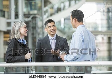 Picture - Business people talking in lobby. Fotosearch
