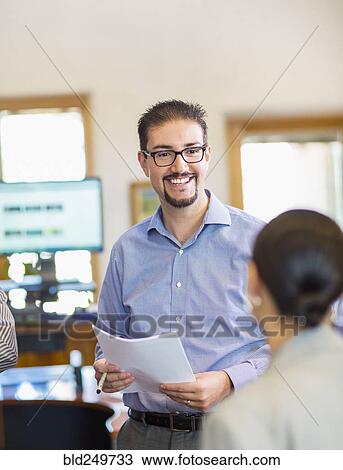 Stock Image - Business people talking in office. Fotosearch