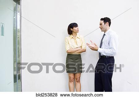 Stock Photo - Business people talking near wall. Fotosearch