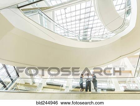 Business people using digital tablet in lobby View Large Photo Image Stock Photograph - Business people using digital tablet in lobby. Fotosearch