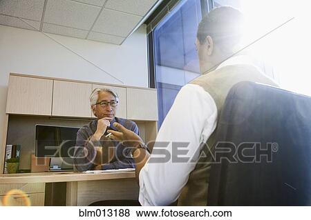 Stock Photo - Business people working together in office. Fotosearch