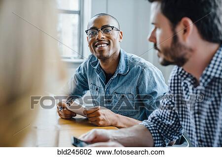 Businessman listening in meeting View Large Photo Image Stock Image - Businessman listening in meeting. Fotosearch