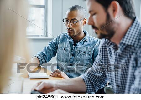 Stock Image - Businessmen in meeting. Fotosearch