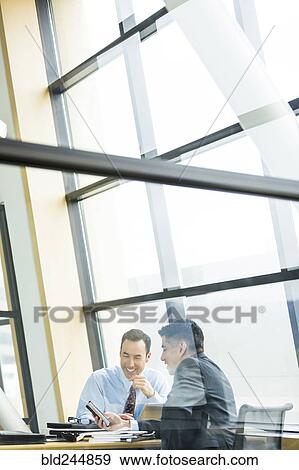 Stock Photo - Businessmen smiling in meeting. Fotosearch