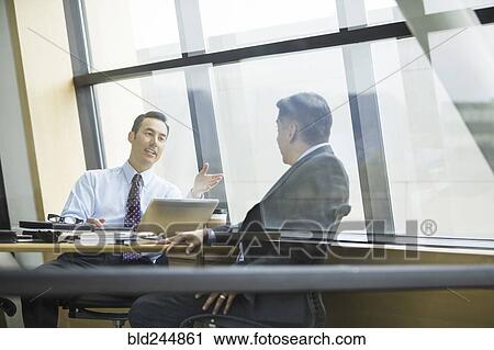 Stock Image - Businessmen talking in meeting. Fotosearch