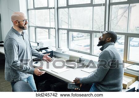 Businessmen talking in office View Large Photo Image Stock Image - Businessmen talking in office. Fotosearch