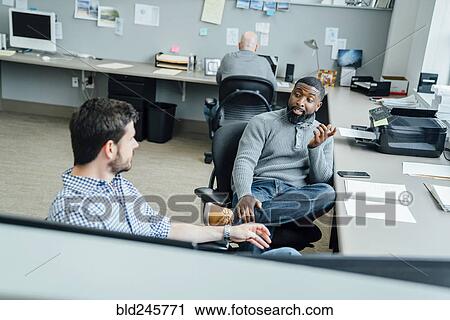 Businessmen talking in office View Large Photo Image Stock Image - Businessmen talking in office. Fotosearch