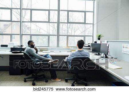 Stock Photography - Businessmen talking in office. Fotosearch
