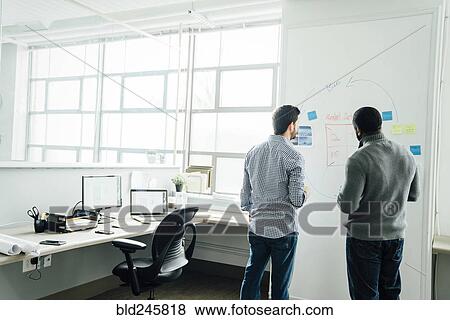 Businessmen using whiteboard in office View Large Photo Image Stock Photo - Businessmen using whiteboard in office. Fotosearch