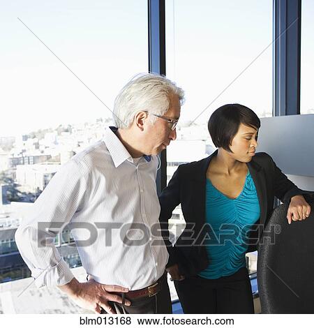 Stock Photo - Businesspeople standing together in office. Fotosearch