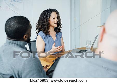 Stock Image - Businesswoman gesturing in meeting. Fotosearch