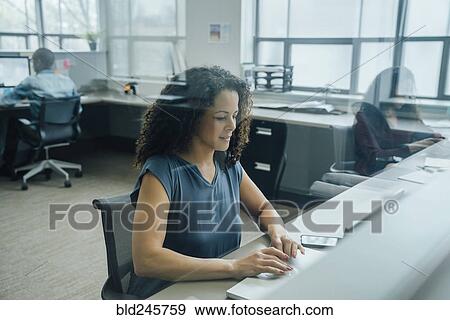 Businesswoman working in office behind window View Large Photo Image Stock Photo - Businesswoman working in office behind window. Fotosearch