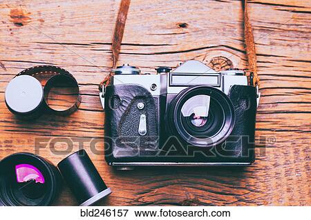 Camera with lens and film on wooden table View Large Photo Image Stock Photo - Camera with lens and film on wooden table. Fotosearch